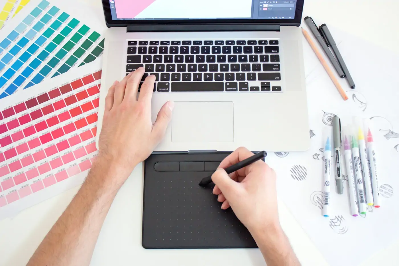 Designer using a graphics tablet and laptop to create a custom Airdrie website
